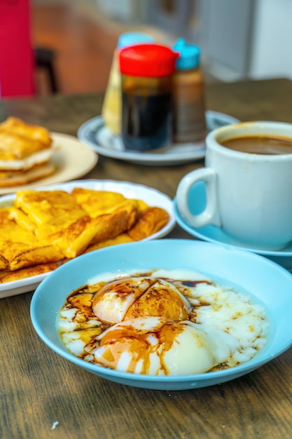 Conjunto tradicional de café da manhã e ovos cozidos com café e torradas populares em Cingapura