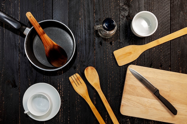 Foto conjunto de utensilios de cocina en el fondo de madera negro.