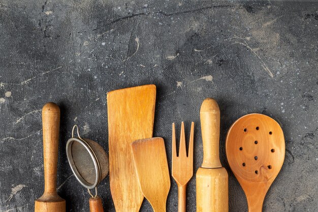 Conjunto De Los Utensilios De Cocina De Madera En El Fondo De Madera.  Cuchara, Mortero, Cocina Espátula, Rodillo, Tazón Tenedor ,. Vista De  Arriba De Los Utensilios De Madera En El Fondo