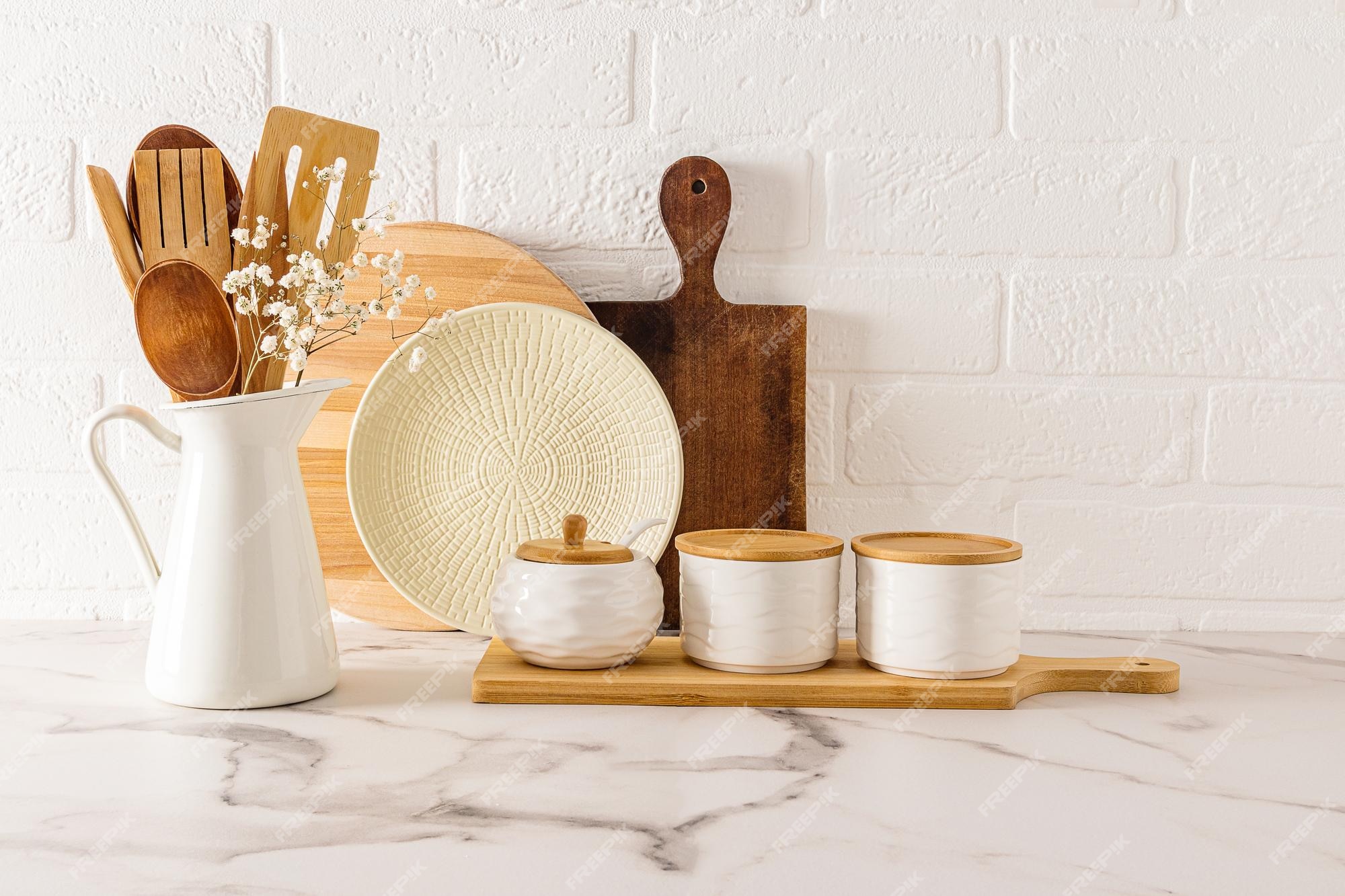 Un conjunto de utensilios de cocina modernos en un estilo minimalista en  una encimera de mármol blanco contra una pared de ladrillos artículos eco