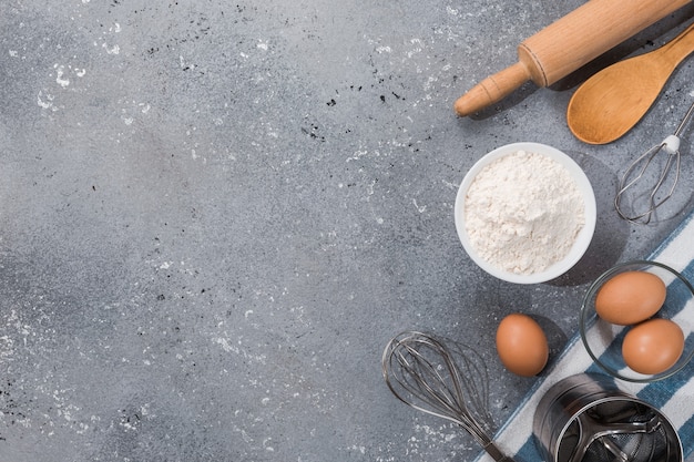 Conjunto de utensilios de cocina con productos sobre fondo azul grisáceo. Clases magistrales de cocina. Copie el espacio.