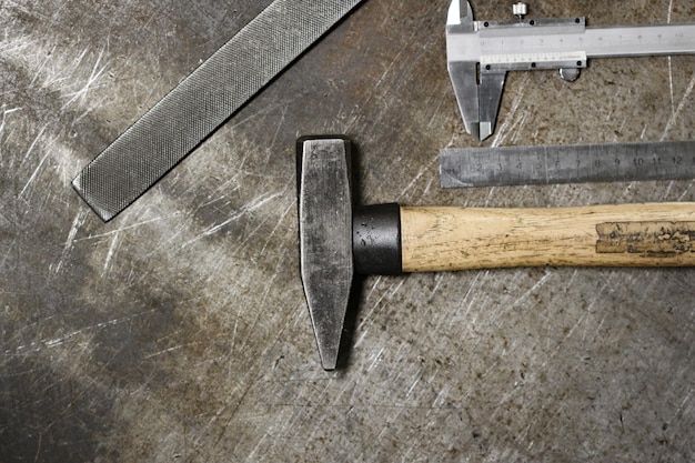 Conjunto de varias herramientas para el hogar que yacen en fila en el viejo estilo de hombres de fondo de metal