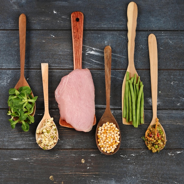 Conjunto de varios ingredientes en cucharas de madera para alimentos para mascotas