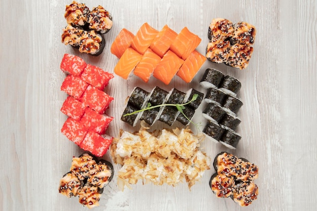 Conjunto de varios rollos de sushi en un fondo de madera blanca comida japonesa