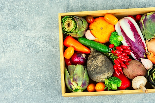 Conjunto de verduras crudas en una caja de madera.