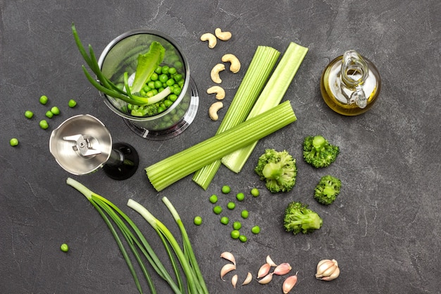 Conjunto de verduras en la mesa y en el tazón de la licuadora