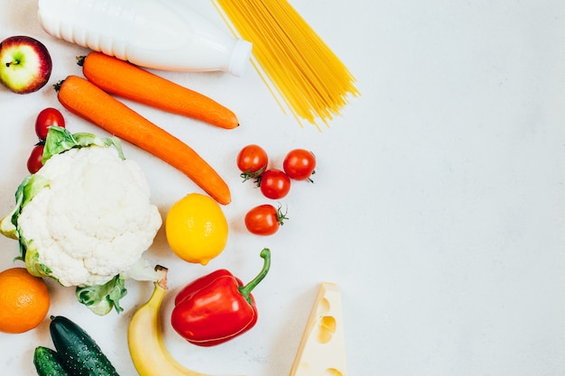 Conjunto de vista superior de alimentos vegetales frutas y productos lácteos sobre fondo blanco con espacio libre