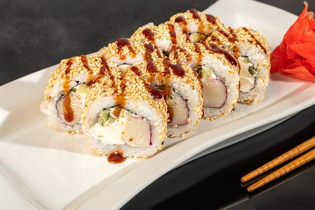 Conjuntos de sushi Uramaki California Philadelphia rolls en un plato blanco Menú para restaurantes cafés Sobre un fondo reflectante oscuro