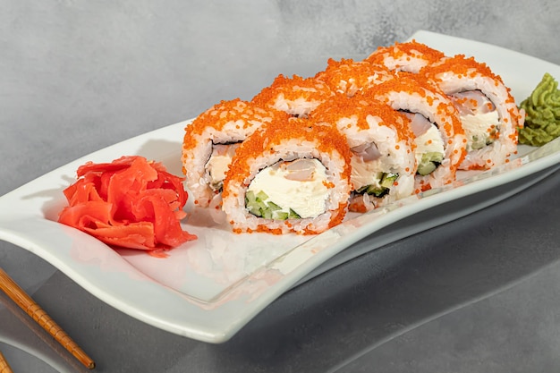 Conjuntos de sushi Uramaki California Philadelphia rolls en un plato blanco Menú para restaurantes cafés Sobre un fondo reflectante oscuro