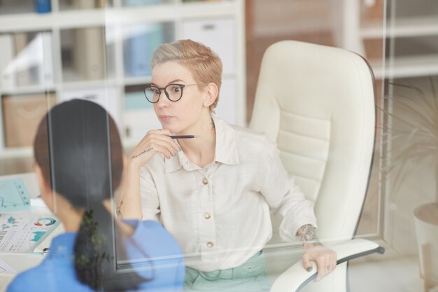 Conmocionada empresaria hablando con un colega en la oficina, espacio de copia