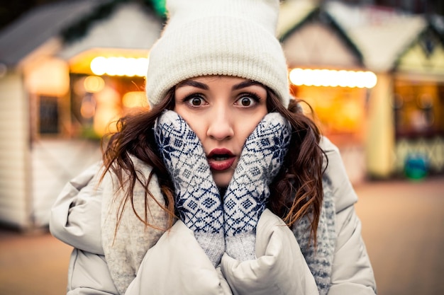 Foto conmocionada mujer de pie en la feria de invierno