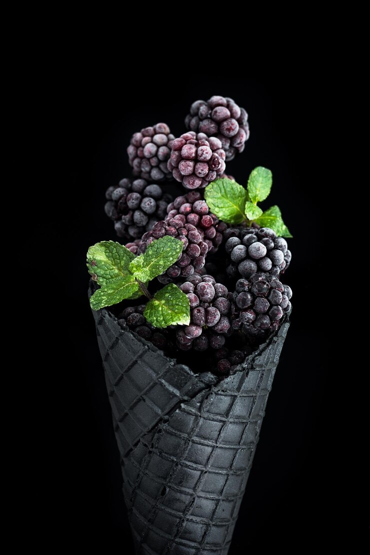 Cono de barquillo negro con helado de frutas de moras congeladas