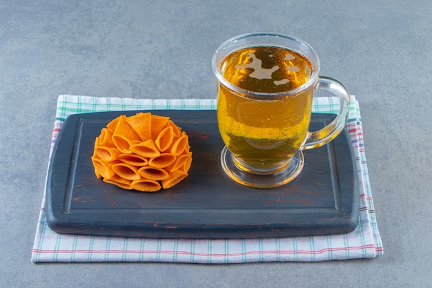 Cono chips y vaso de cerveza en una bandeja sobre la toalla, sobre la superficie de mármol.