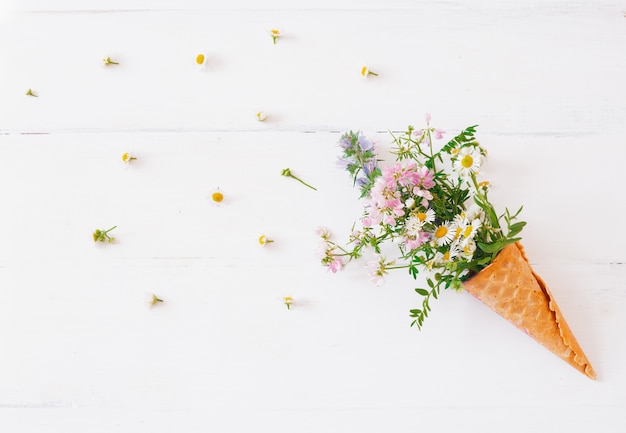 Cono de galleta con flores silvestres en blanco