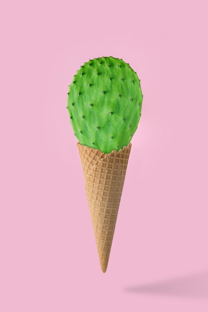 Cono de helado con cactus verde aislado en rosa