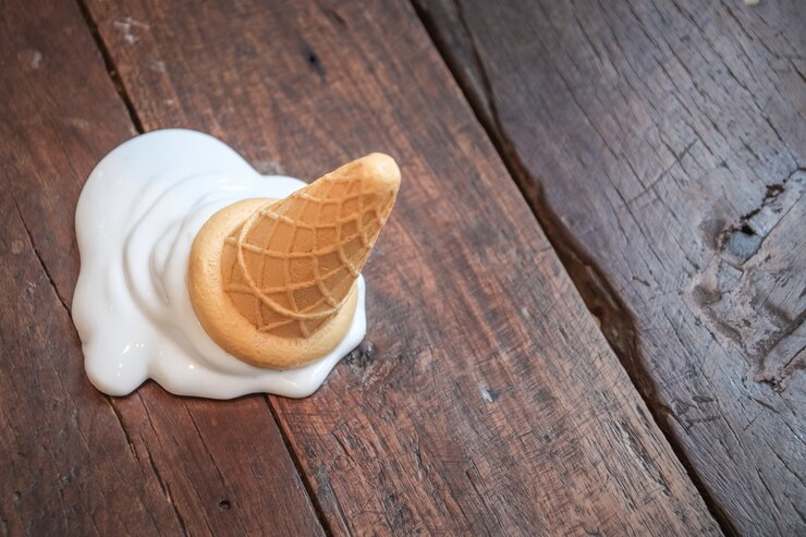 Cono de helado caído sobre el piso de madera.