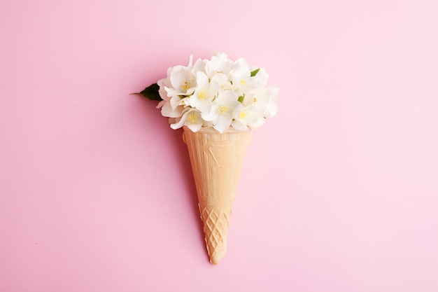 Cono de helado de gofres con flores de jazmín