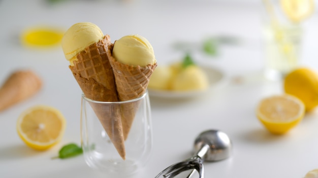 Cono de helado de limón con limón y relleno en mesa blanca