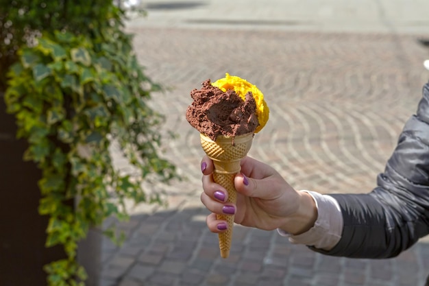 Cono de helado en la mano en la calle