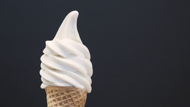 Cono de helado de servicio suave sobre fondo negro. (de cerca )