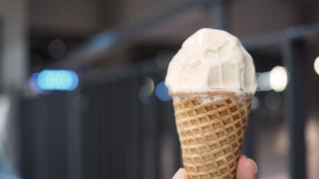 El cono de helado suave se muerde y se derrite en la mano.