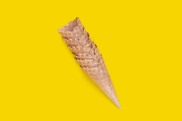 Cono de helado vacío sobre fondo amarillo