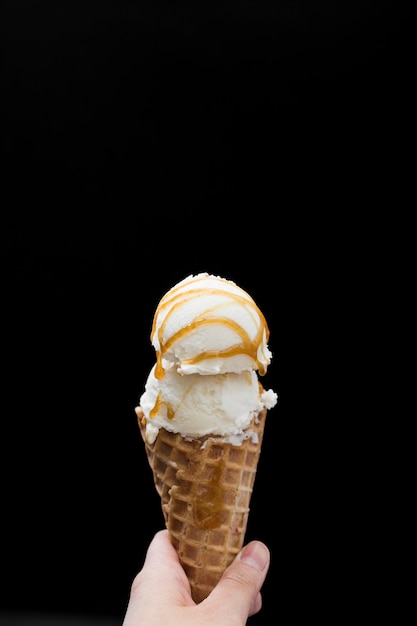 Foto cono de mano con helado con sabor
