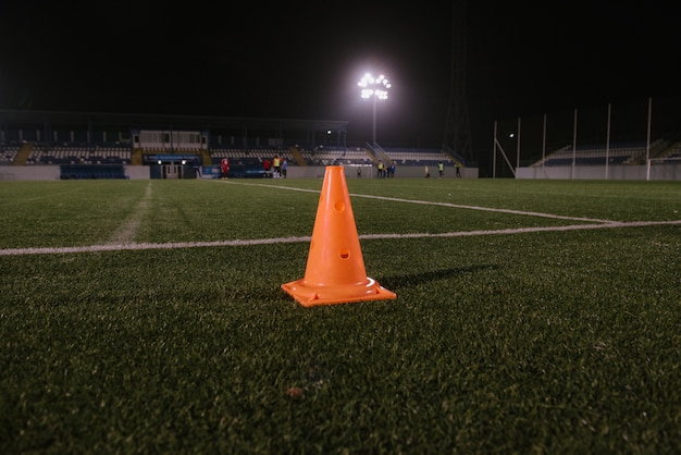 Cono naranja para entrenar fútbol en el campo