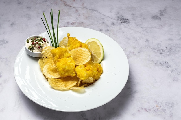 Cono de papel con pescado y patatas fritas caseras