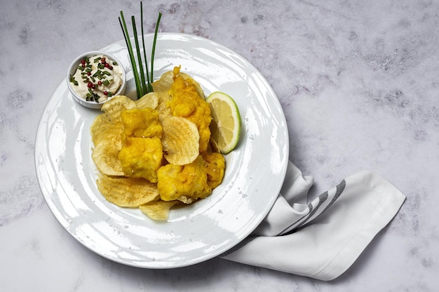 Cono de papel con pescado y patatas fritas caseras