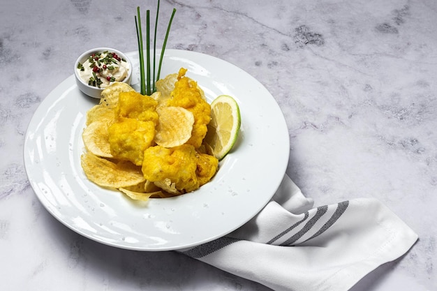 Cono de papel con pescado y patatas fritas caseras