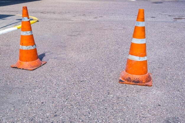 Cono de peligro de tráfico naranja blanco en la reparación de carreteras de asfalto