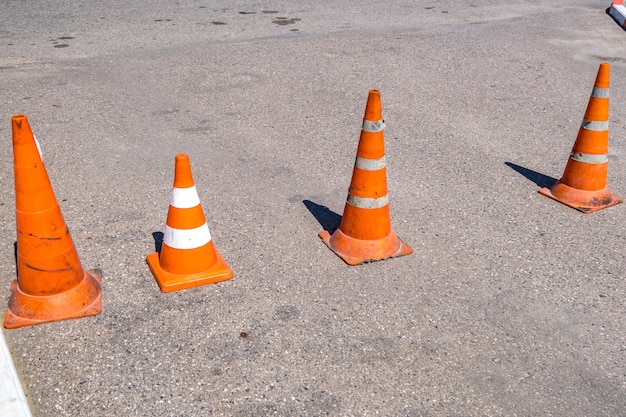 Cono de peligro de tráfico naranja blanco en la reparación de carreteras de asfalto