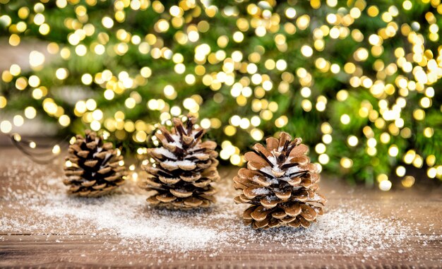 Cono de pino y ramas de árboles de Navidad. Decoración festiva con guirnaldas de luces.