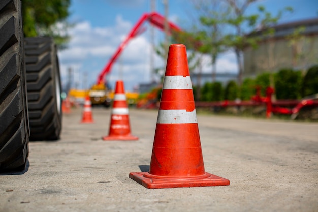 Cono de tráfico naranja en el estacionamiento cerca de la carretilla elevadora grúa hidráulica.