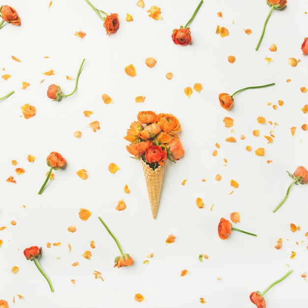 Cono de waffle con flores de ranúnculo naranja Concepto de estado de ánimo de primavera o verano