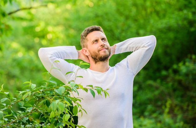 Conoce un nuevo día Naturaleza ambiente pacífico Remedios de belleza natural Mantenlo saludable Naturaleza relax spa resort Siente el poder de la naturaleza Hombre guapo barbudo mañana estirando el fondo de la naturaleza