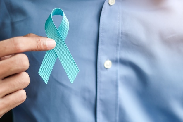 Conocimiento del cáncer de próstata, hombre que sostiene la cinta azul claro