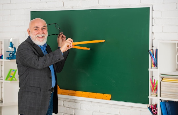 Conocimiento útil Tendencias educativas Los sistemas de aprendizaje adaptativo usan datos ajustan la escala individual de aprendizaje Profesor de hombre inteligente senior en la pizarra Metas educativas Concepto de educación escolar