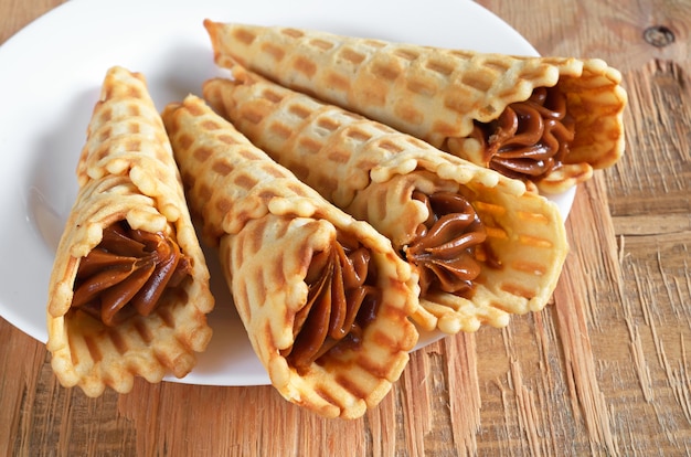 Conos de galleta con dulce leche condensada hervida en una placa