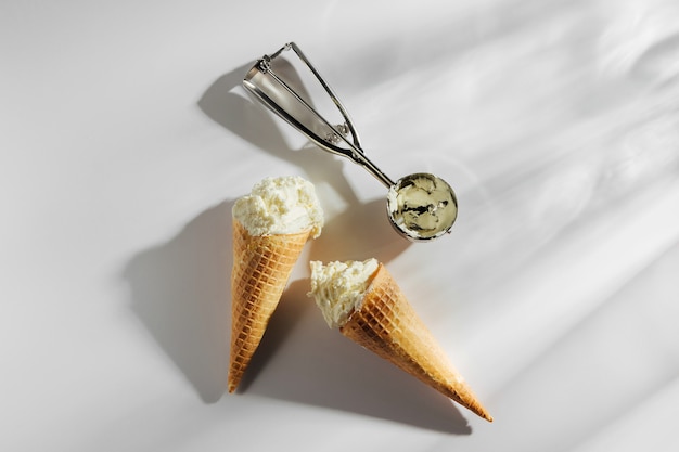 Conos de helado con cuchara sobre fondo blanco. Concepto de verano.