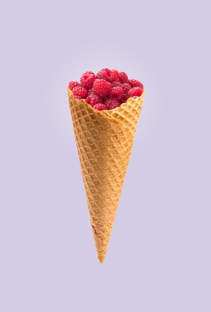 Conos de helado con frambuesas aislado sobre un fondo violeta pastel
