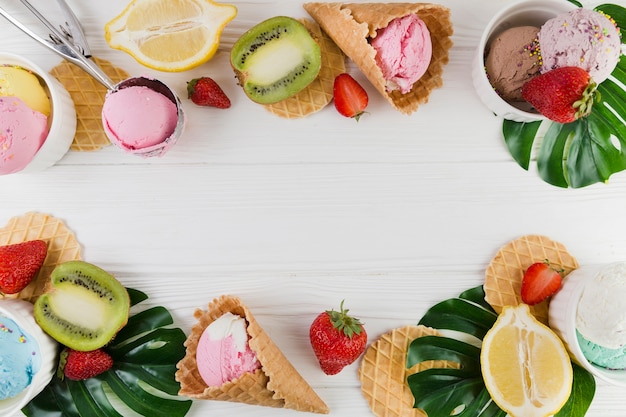 Foto conos de helado, frutas y hojas verdes.