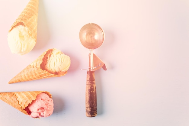 Conos de helado de galleta con bolas de helado sobre un fondo azul.