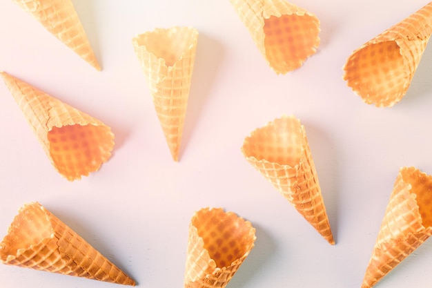 Conos de helado de gofres vacíos sobre un fondo azul.