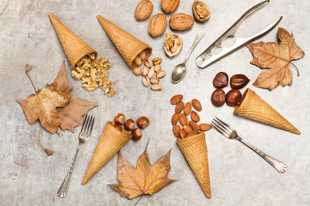 Conos de helado con nueces sobre una mesa de mármol