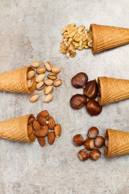 Conos de helado con nueces sobre una mesa de mármol