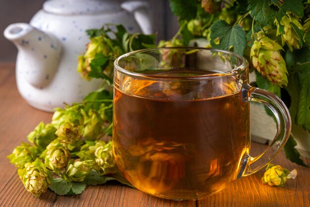 Conos de lúpulo de hierbas y té de flores Bebida caliente alternativa cruda orgánica con conos de lúpulo fresco en el espacio de copia de mesa de madera