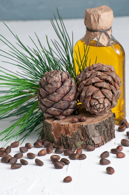 Conos de pino y productos de cedro nueces y aceite de cedro Macro de primer plano sobre un fondo gris