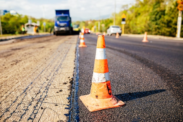 Conos de tráfico en la carretera Una gran capa de asfalto caliente fresco Construcción de carreteras